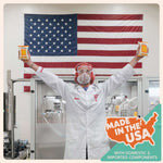 Person in lab coat holding products with American flag in background, showcasing Made in the USA.